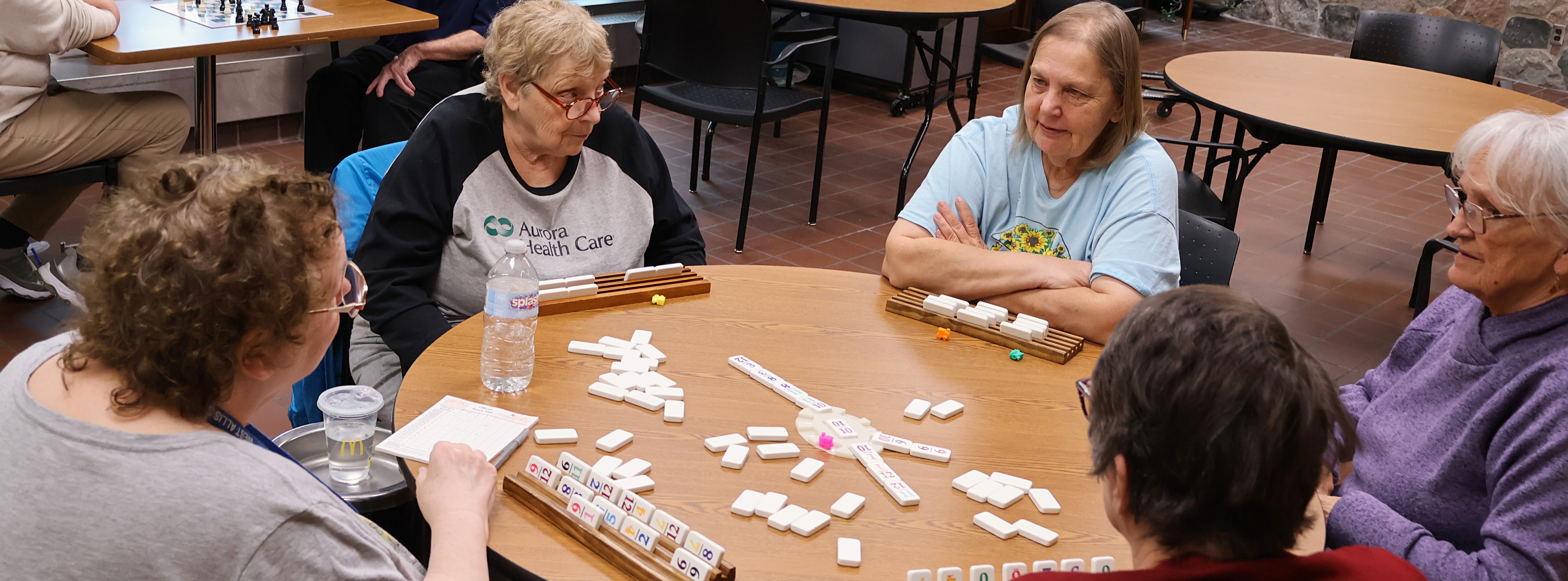 People sitting around a table playing mahjong