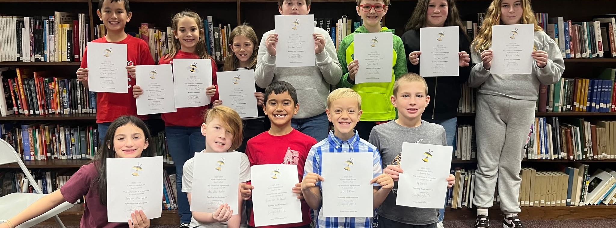 Students talking a picture in the library with their reading certificate