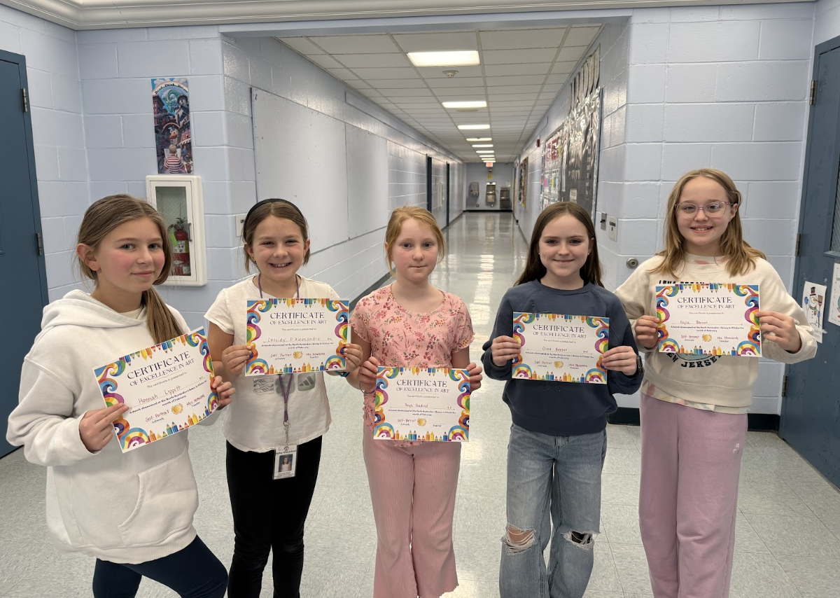 Picture of five girls holding certificates in a school hallway