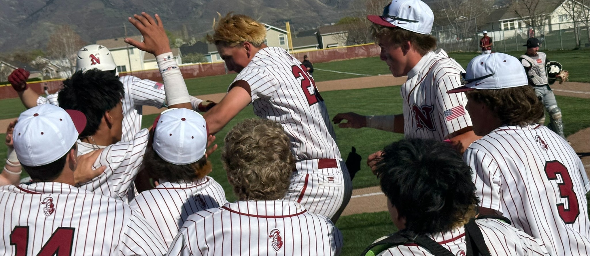 Baseball athletes celebrating a win jumping in each others arms