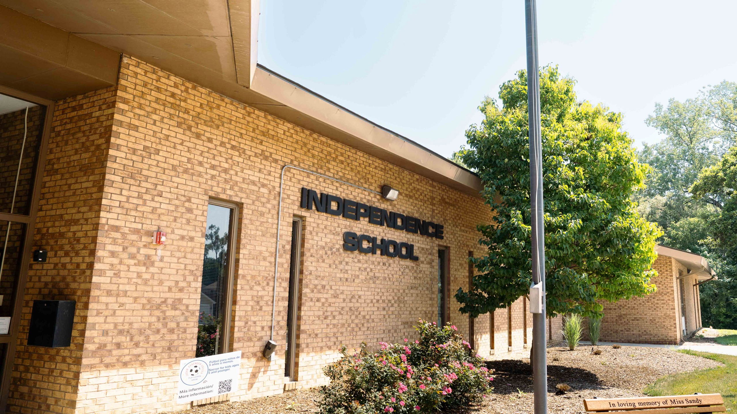Exterior of a brick building with a sign that reads "Independence School" above a window.