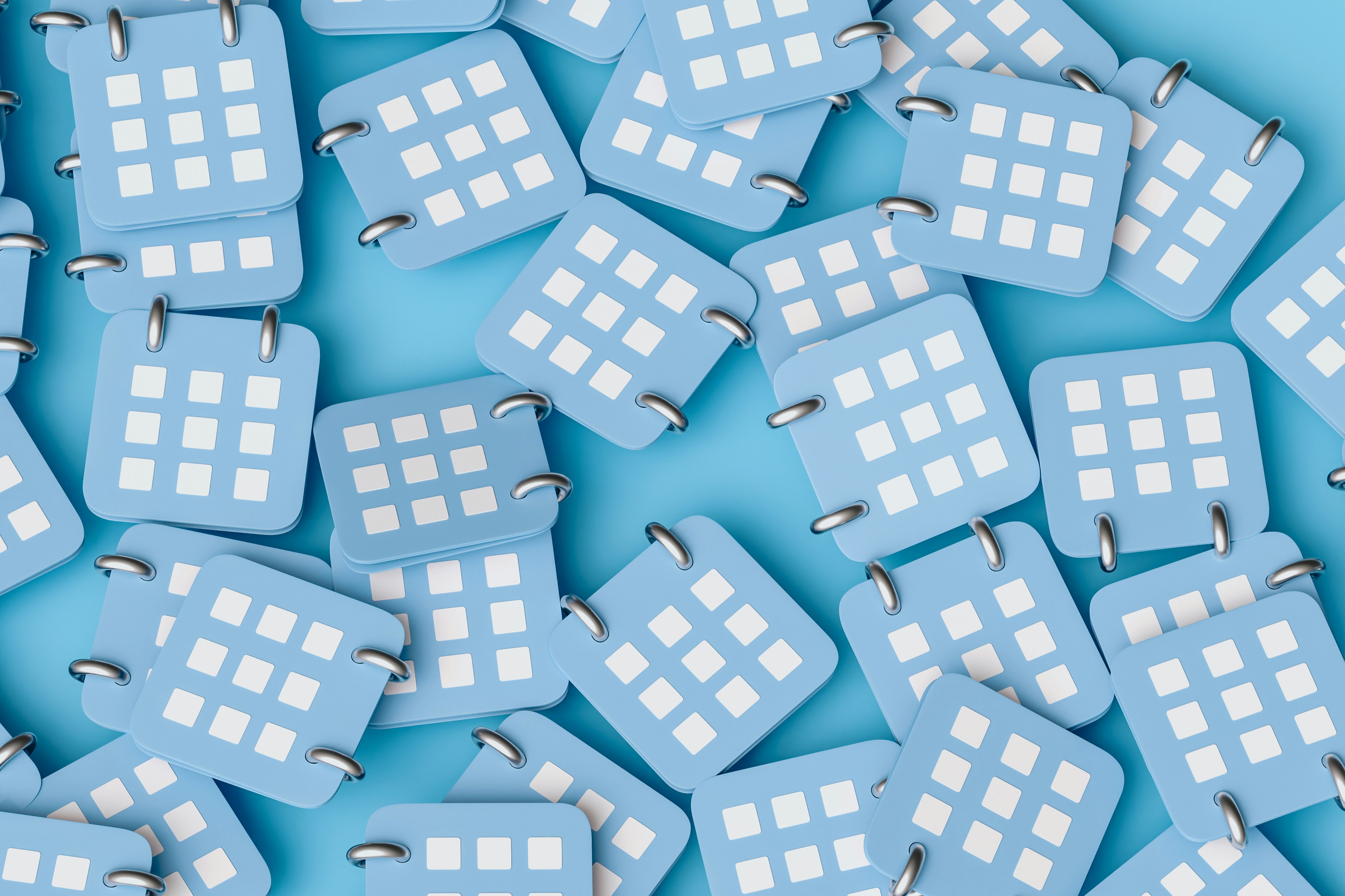Multiple blue and white square objects with grid patterns and metal rings scattered on a light blue background.