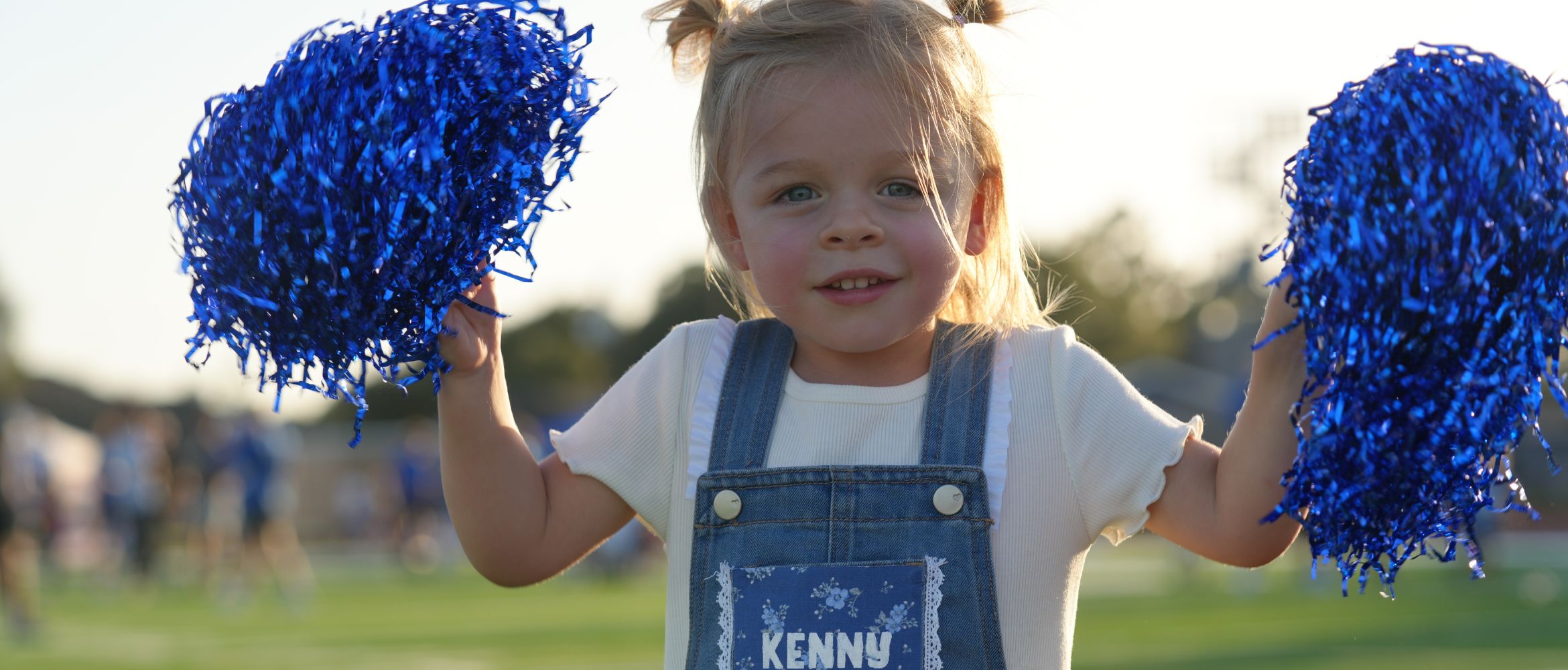 Little girl with blue pompoms