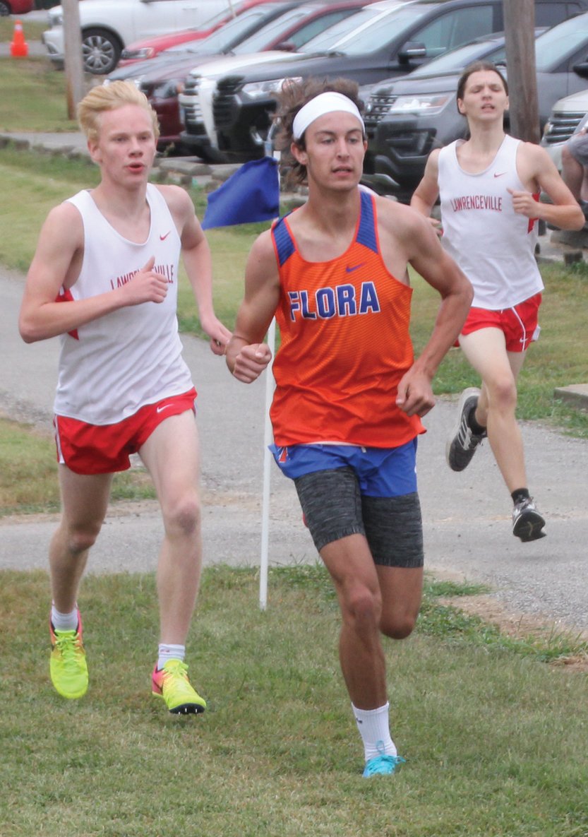 Lawrence County's Brayden Green (left) and Seth Seitzinger (right) run at the front of the field along with Flora's Isaac Stanford during Saturday's cross country race at Lawrenceville City Park