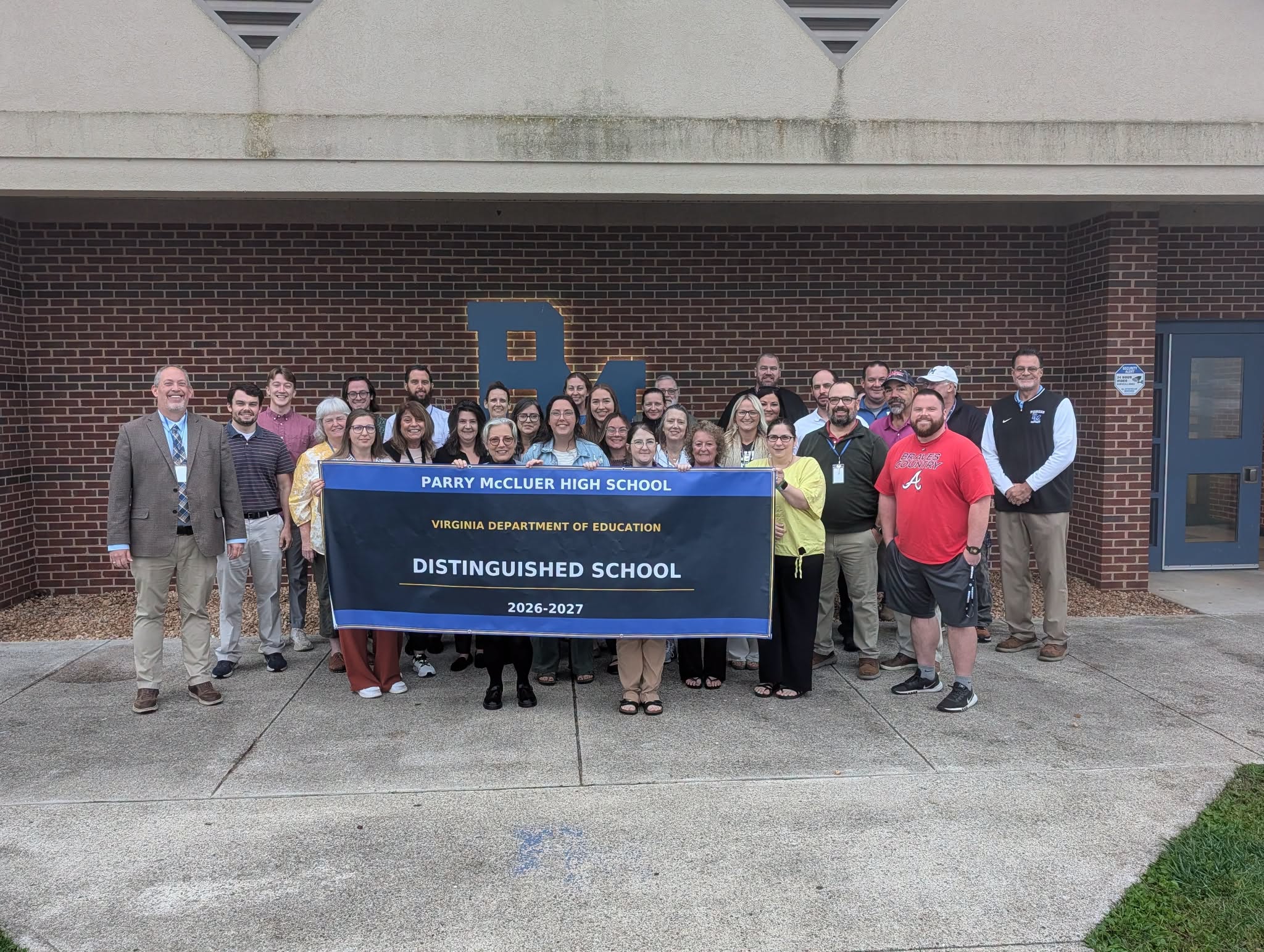 PMHS Staff holding Distinguished School Banner