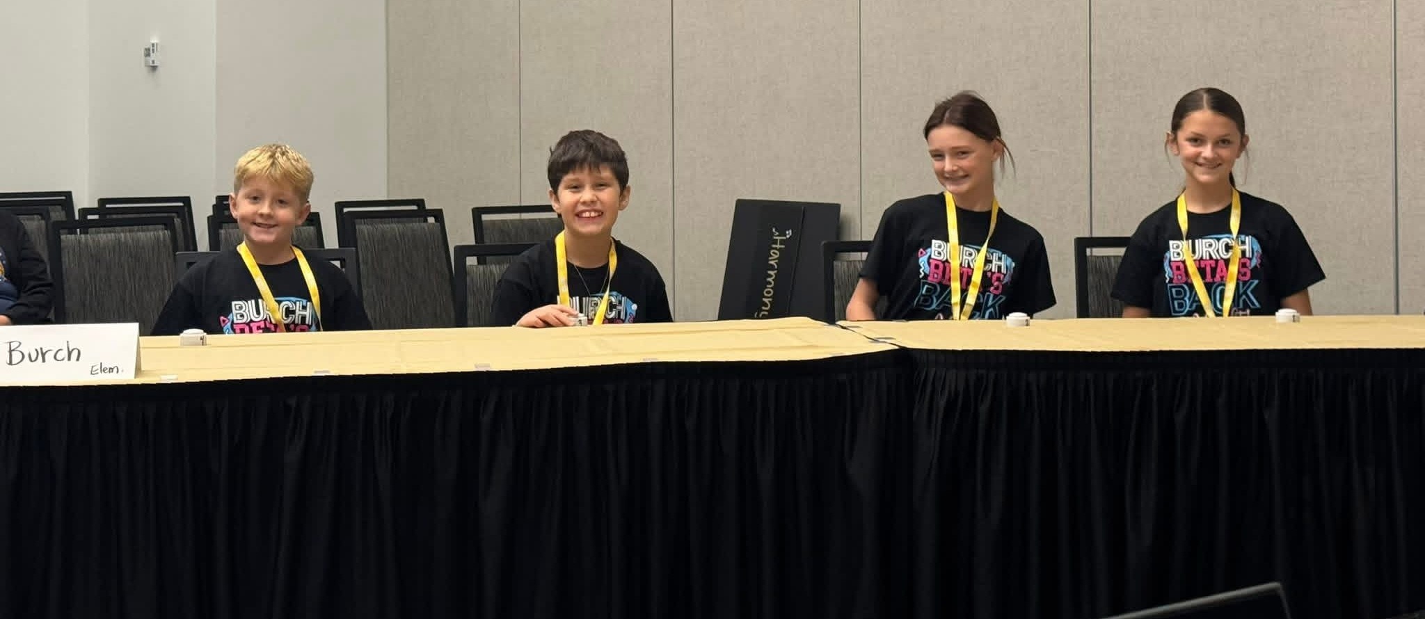 Students sitting at a table with black shirts on 