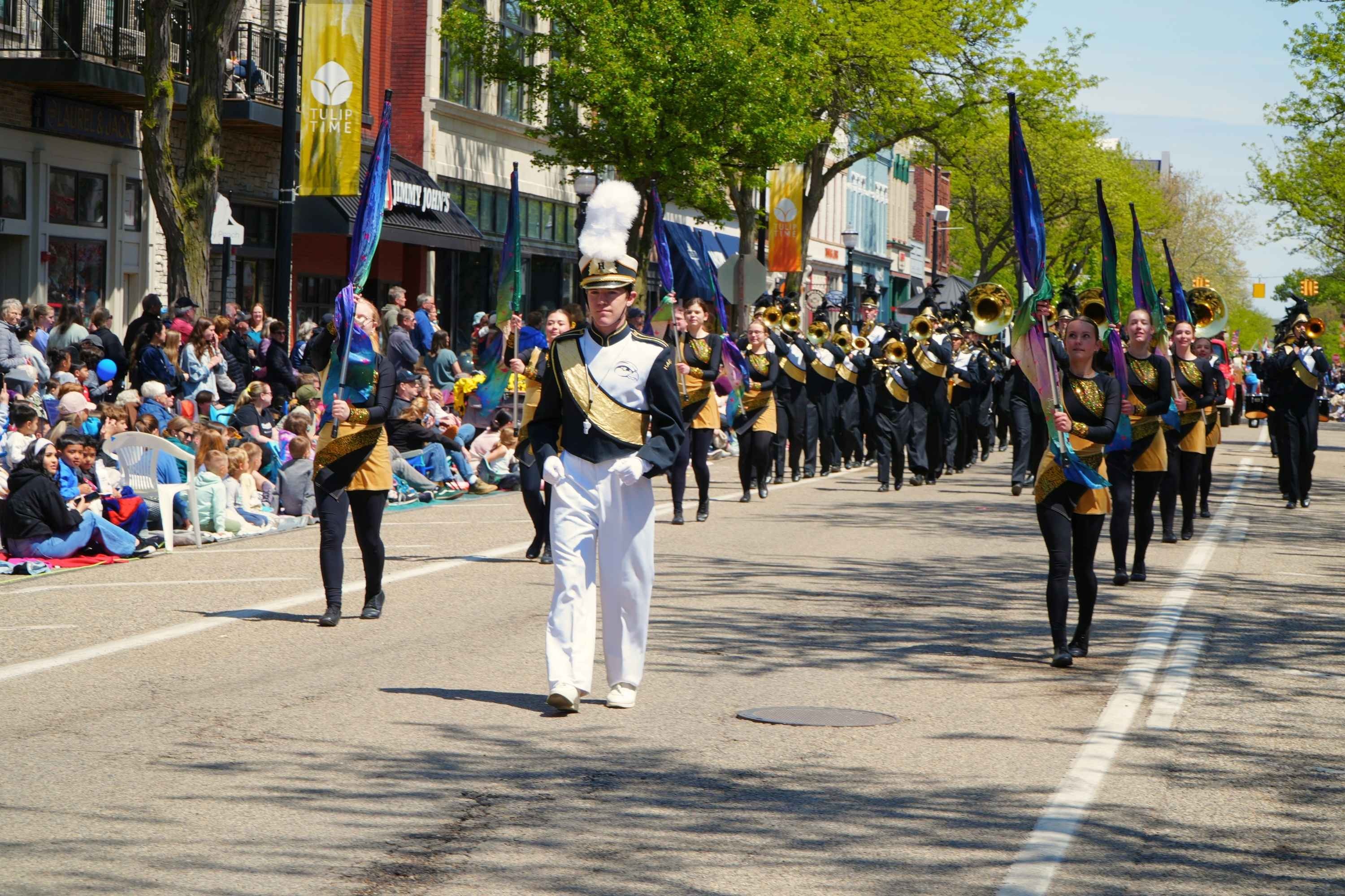 A band marches down a street during a parade.