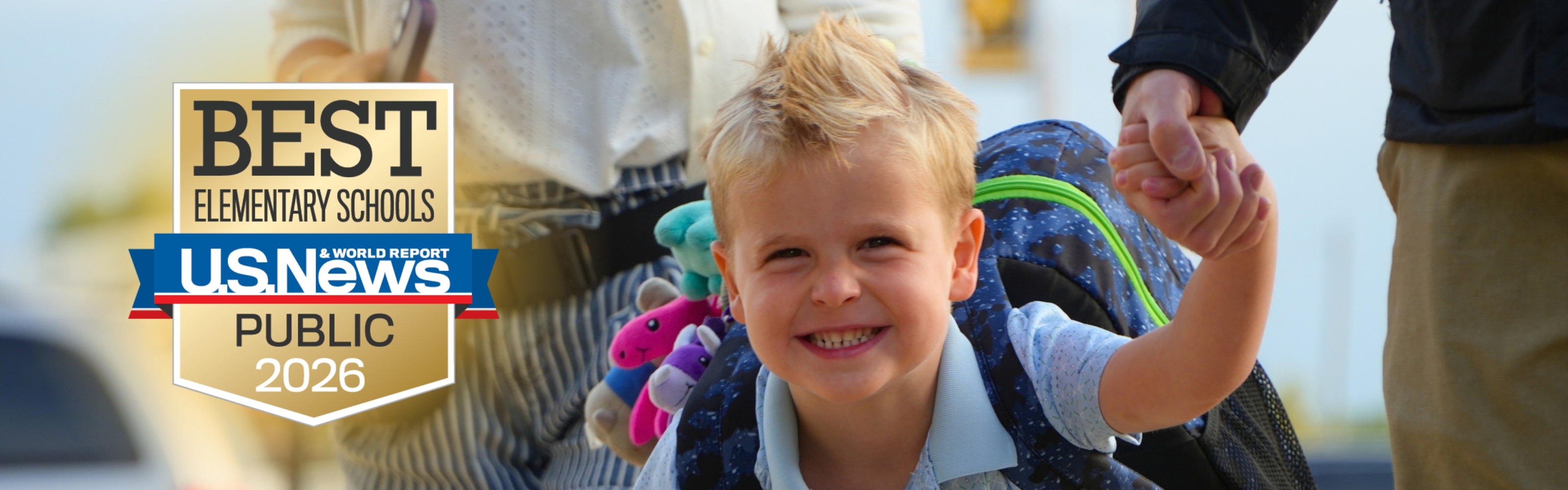 A male student with blonde hair runs towards a camera and smiles.