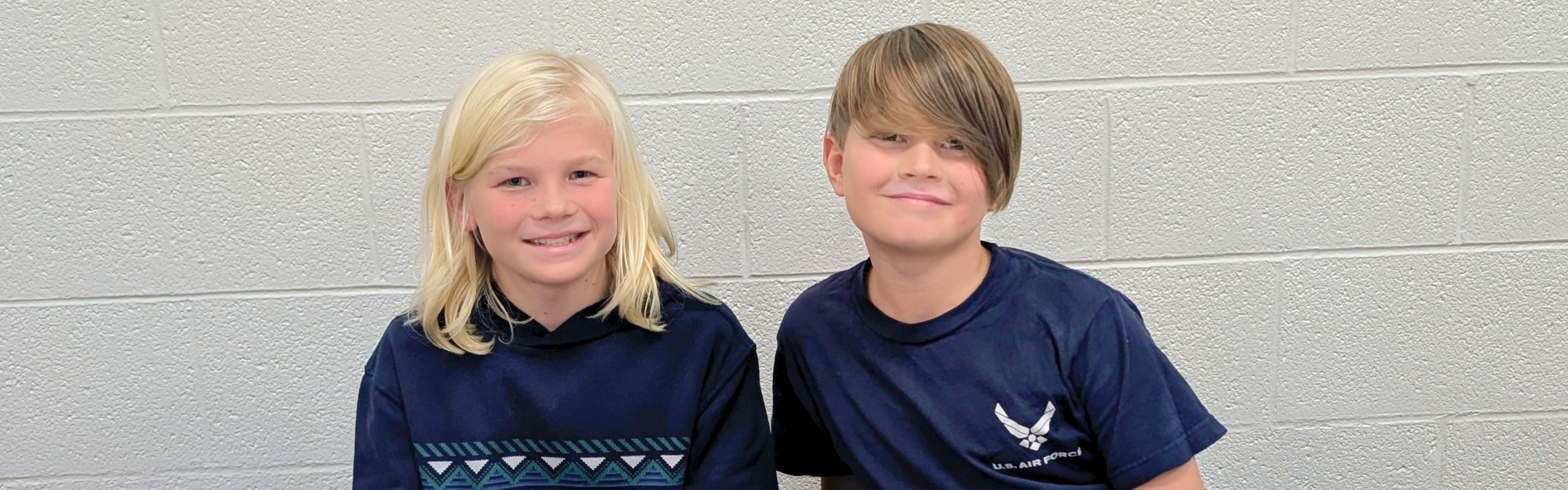 Two students smile.