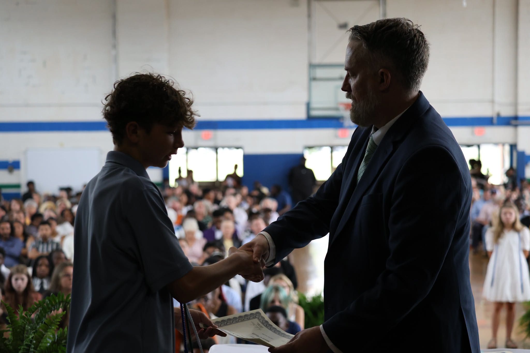 a student shakes hands with the principal on awards day
