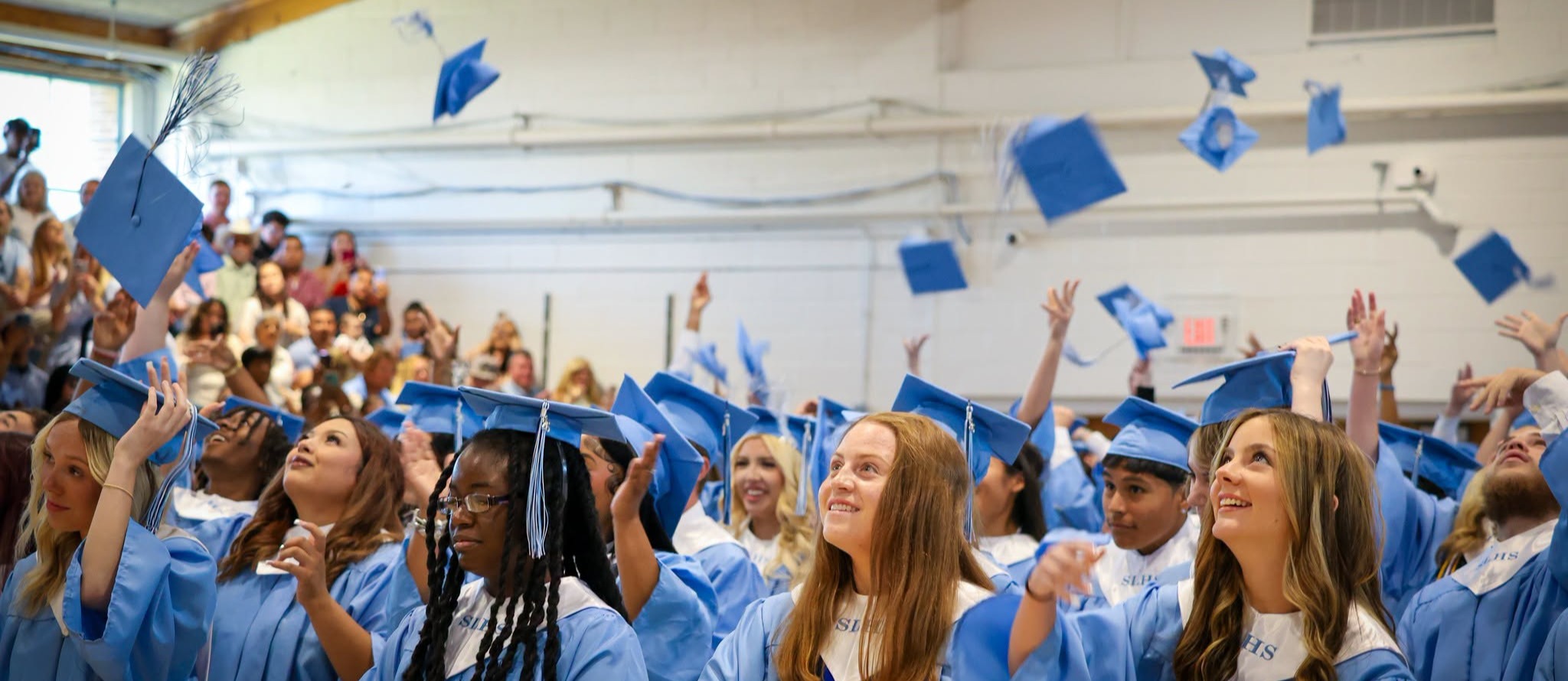 graduates celebrate in the gym