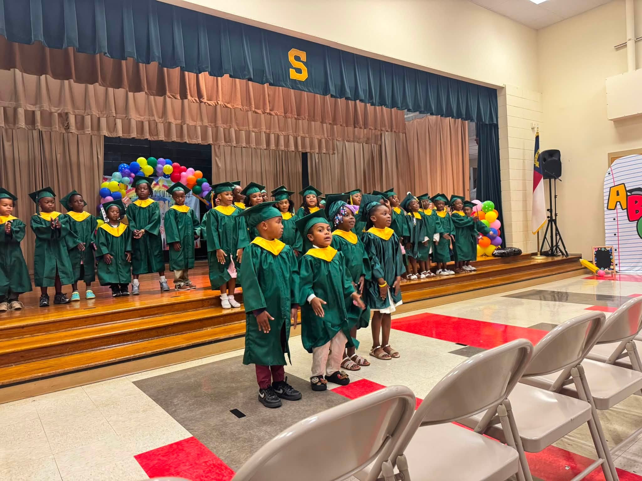 kindergarten students stand in robes ready to move up