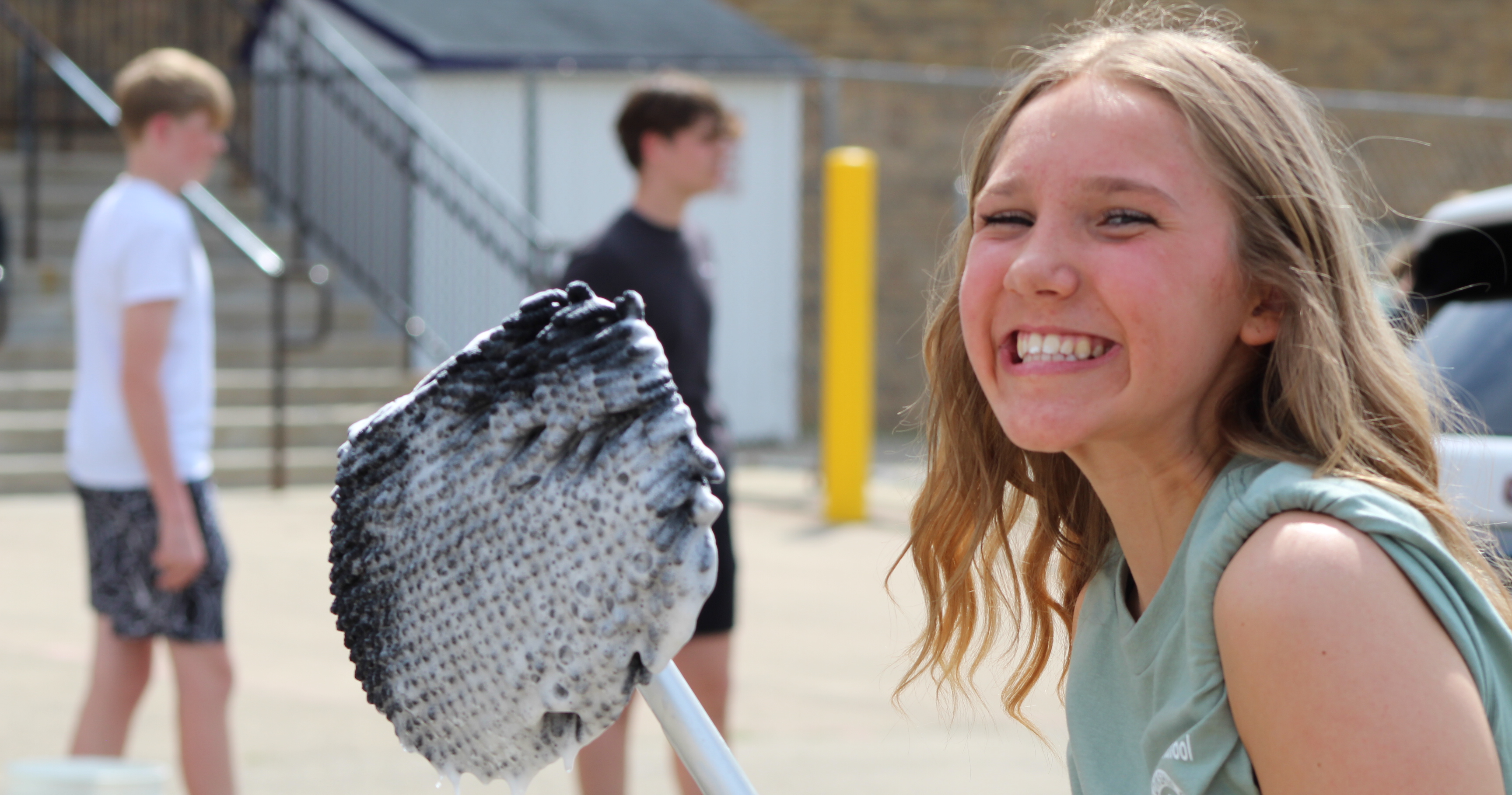 student smiling while working the FCA car wash