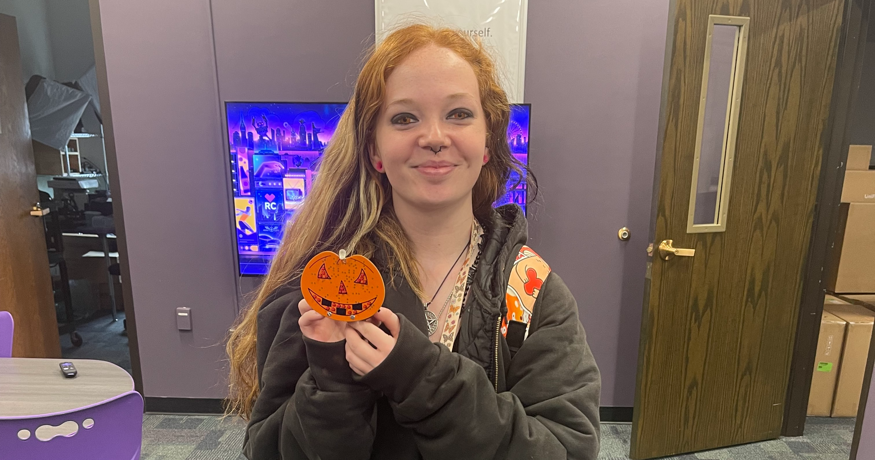 Adalyn Hitt holding pumpkin soldered by tech director jim manley