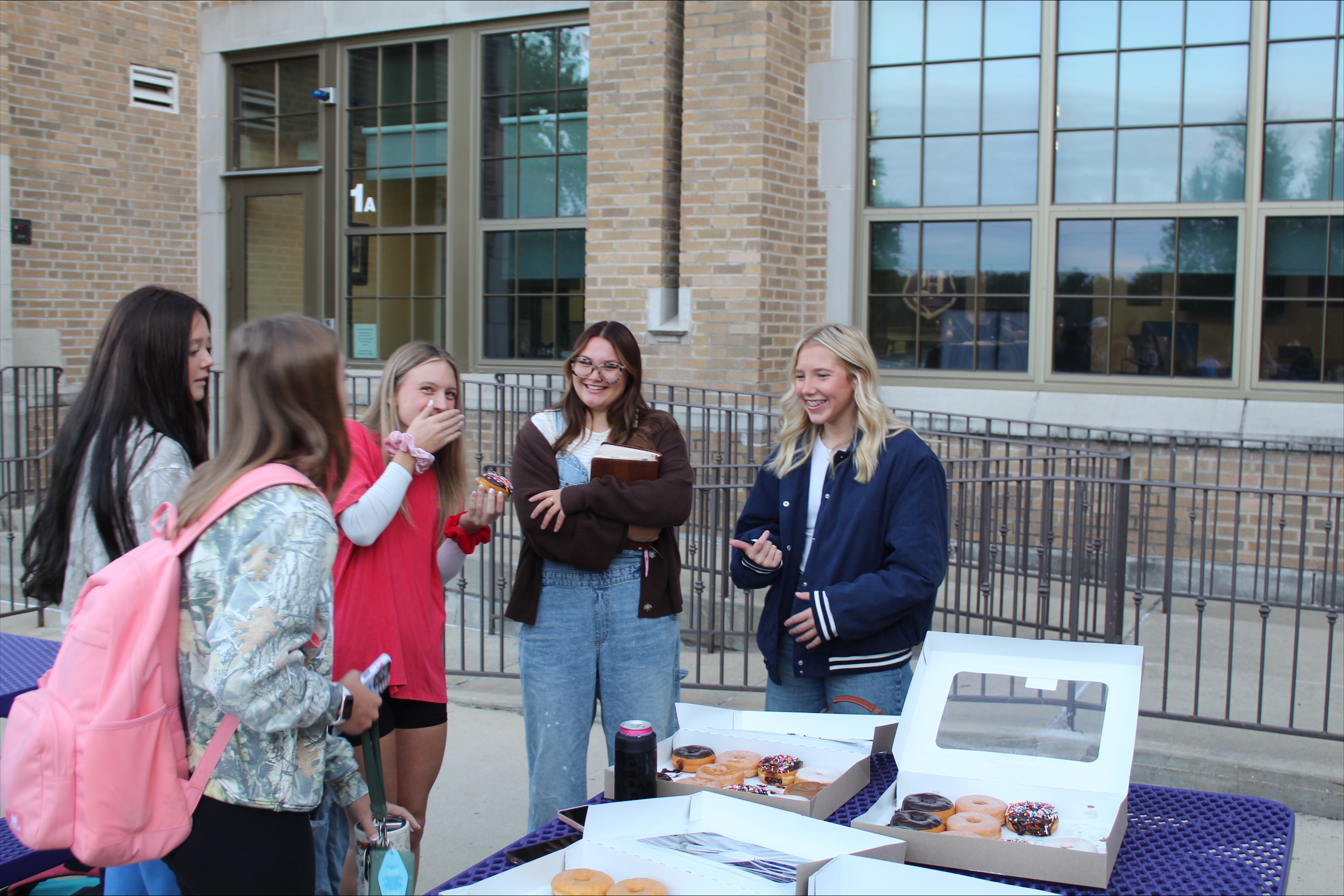 students handing out donuts for fellowship