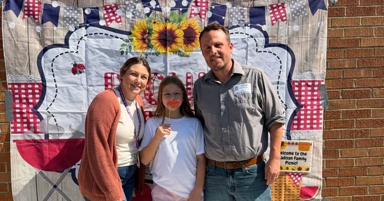 Students and parents at picnic smiling for camera