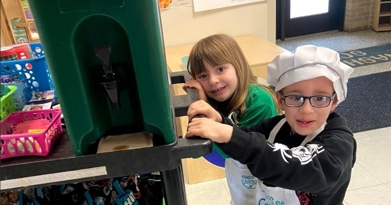 washington students smling for camera pushing snack cart