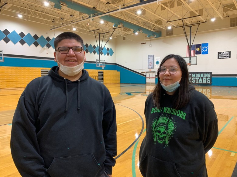 two students smile in gym