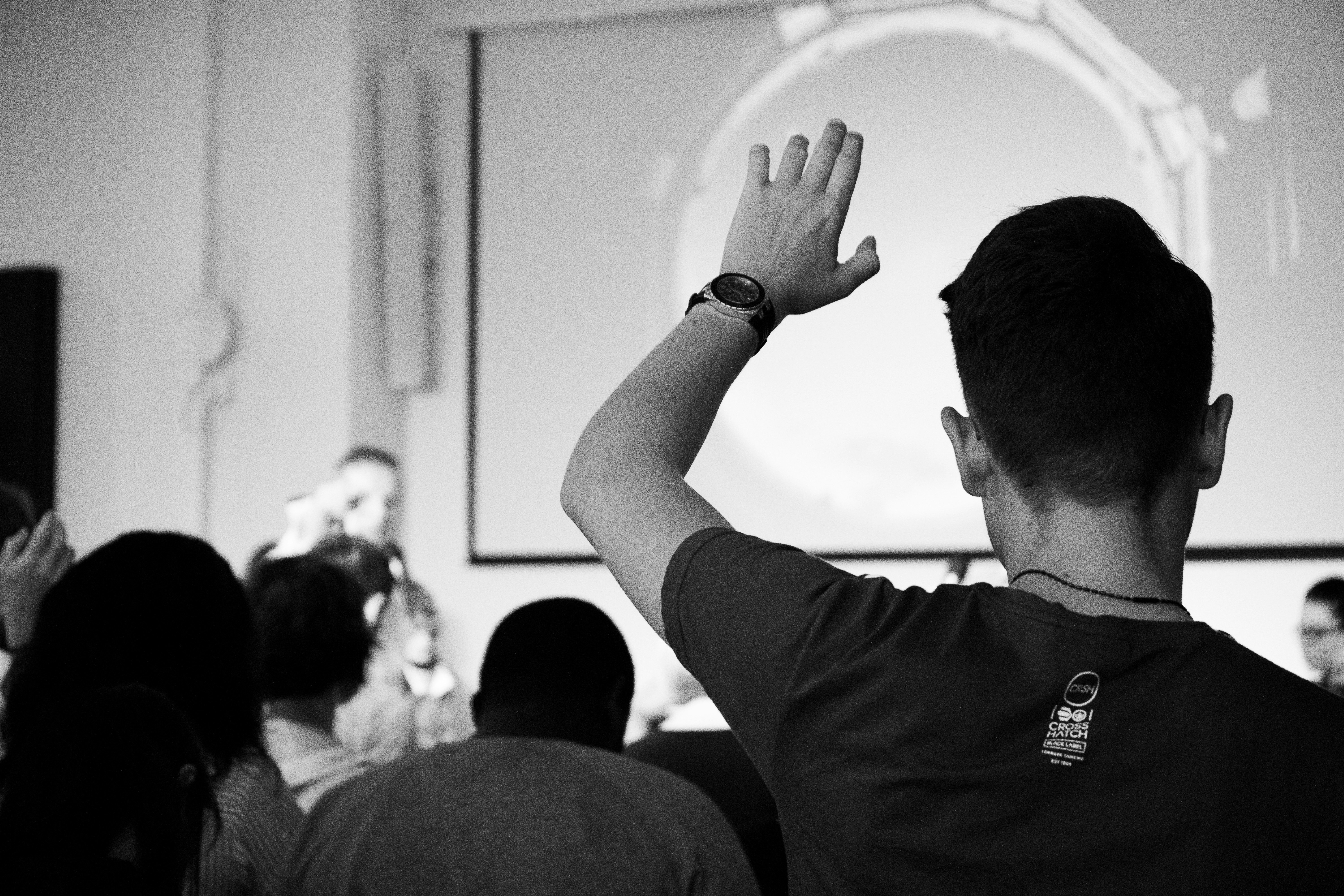 Image of student raising hand in lecture