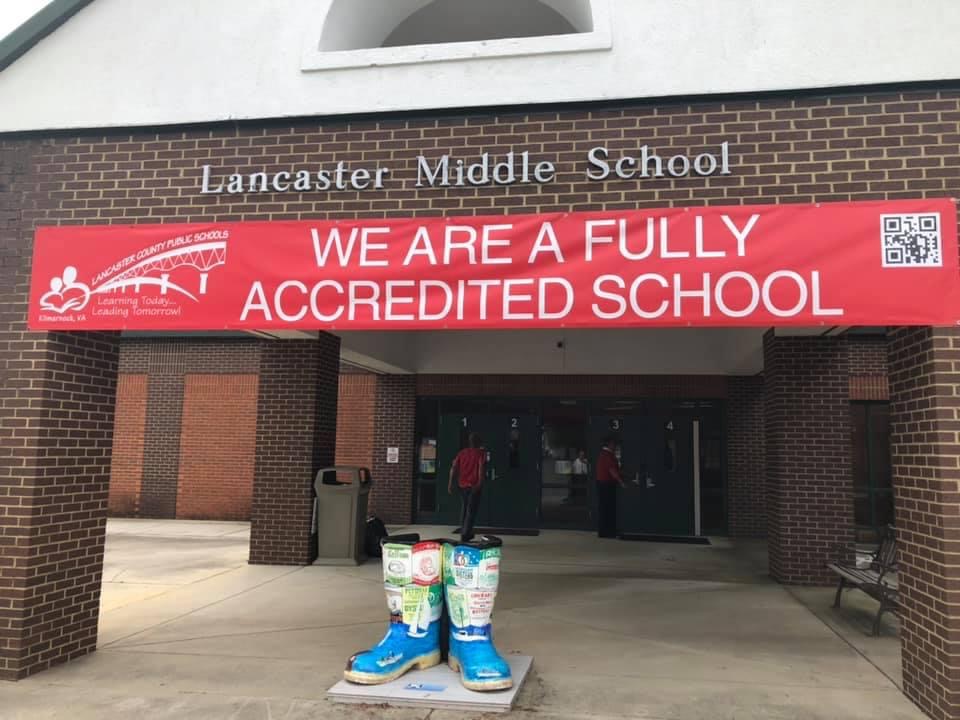picture of the front of Lancaster Middle School with a banner that reads "we are a fully accredited school"