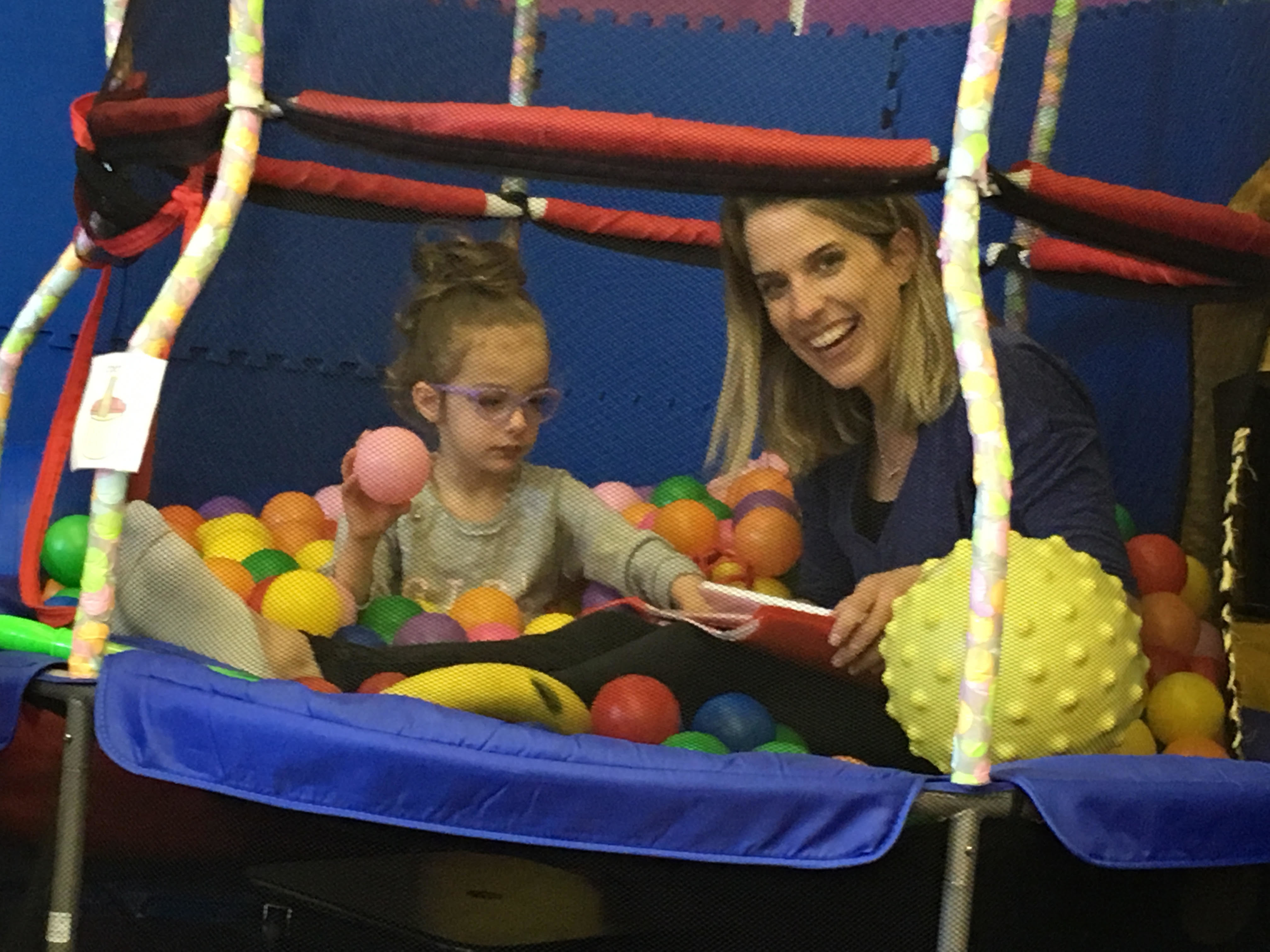 Speech teacher in ball pit with student