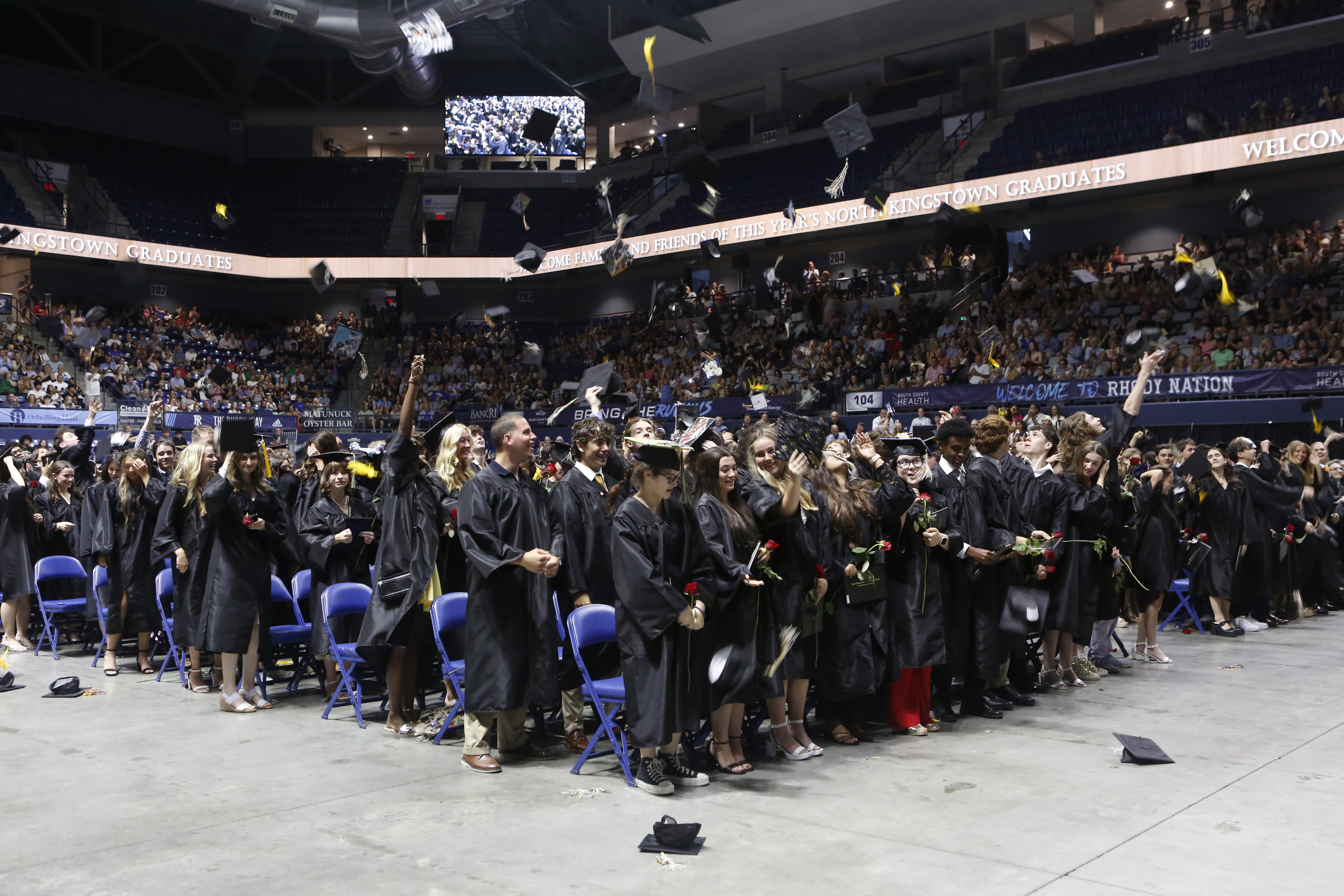 North Kingstown High School Graduates throwing caps into the air.
