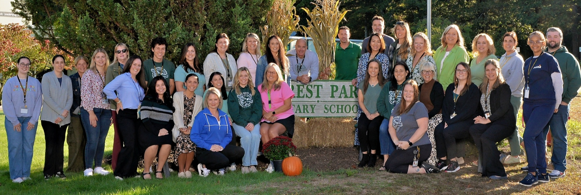 Staff in front of Forest Park Sign