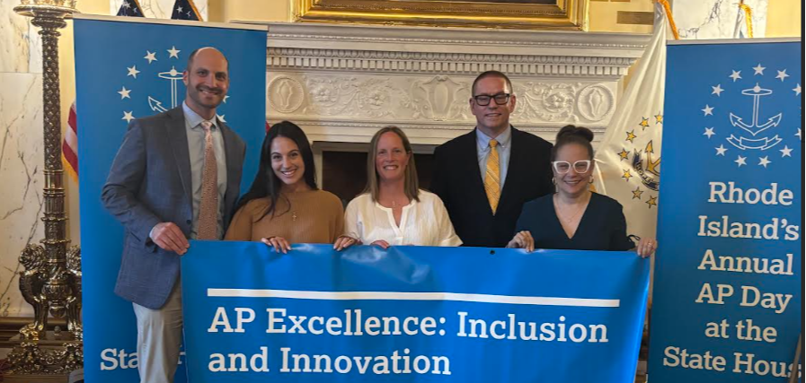 Five people hold a blue banner with the words "AP Excellence: Inclusion and Innovation" in a room.