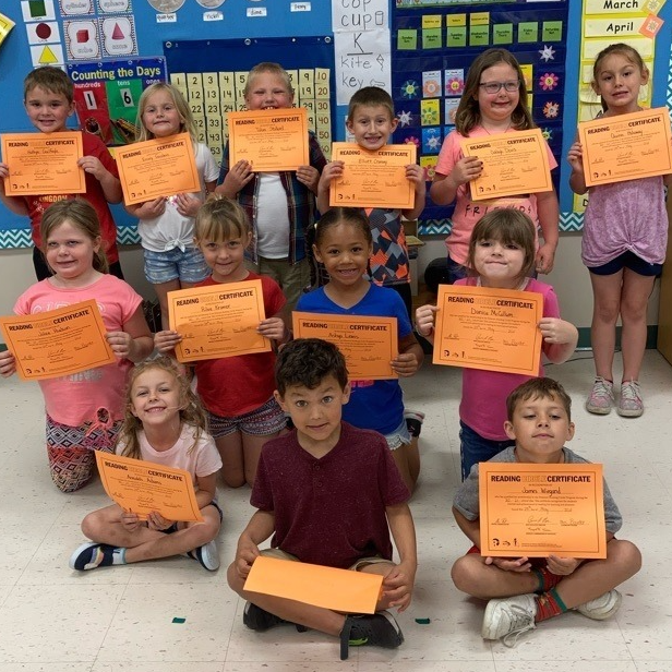 Elementary students hold certificates