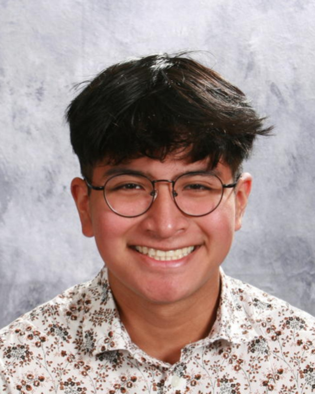 smiling boy with dark hair and glasses