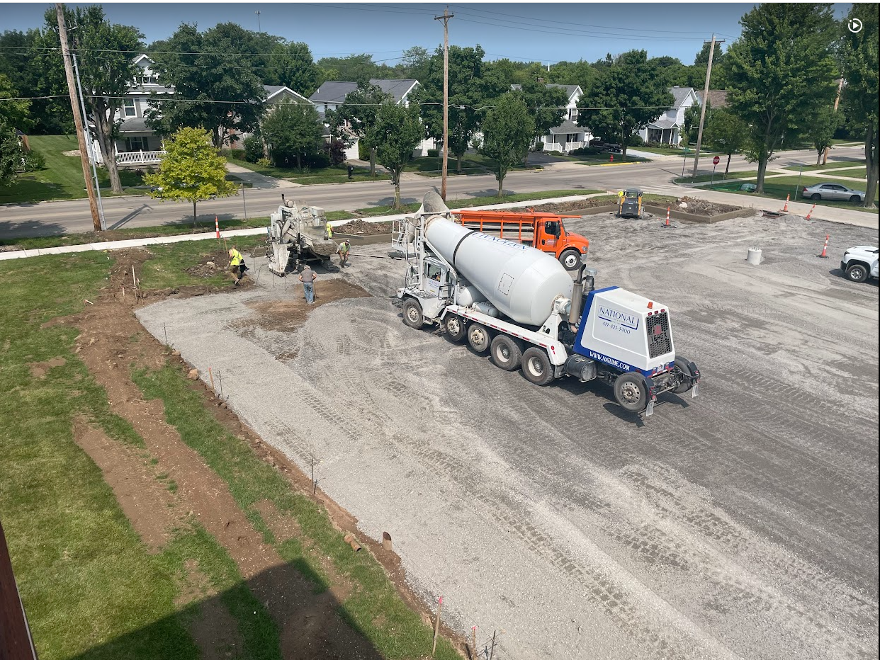 Trucks pouring concrete for curbs