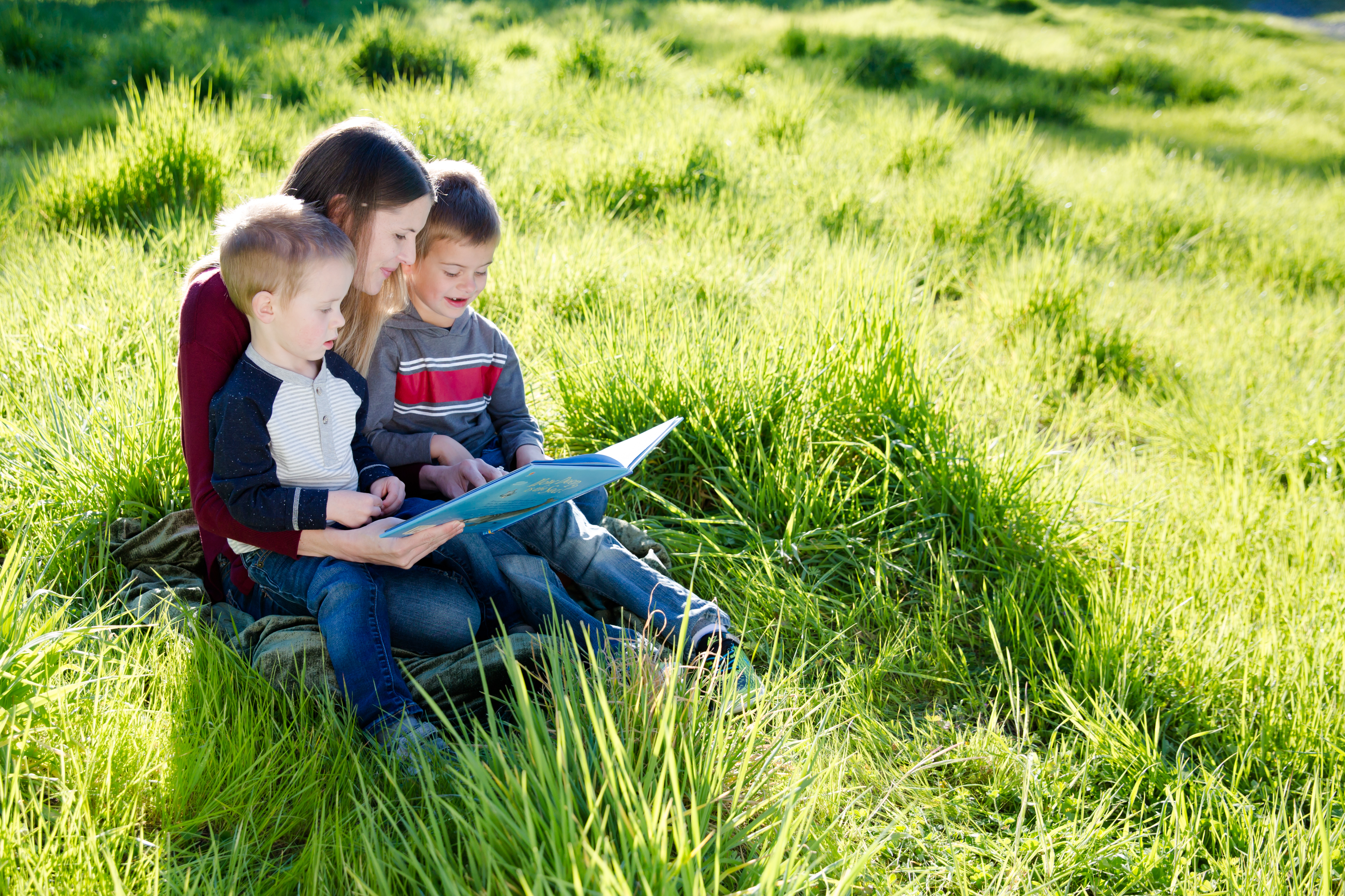 family reading in grass