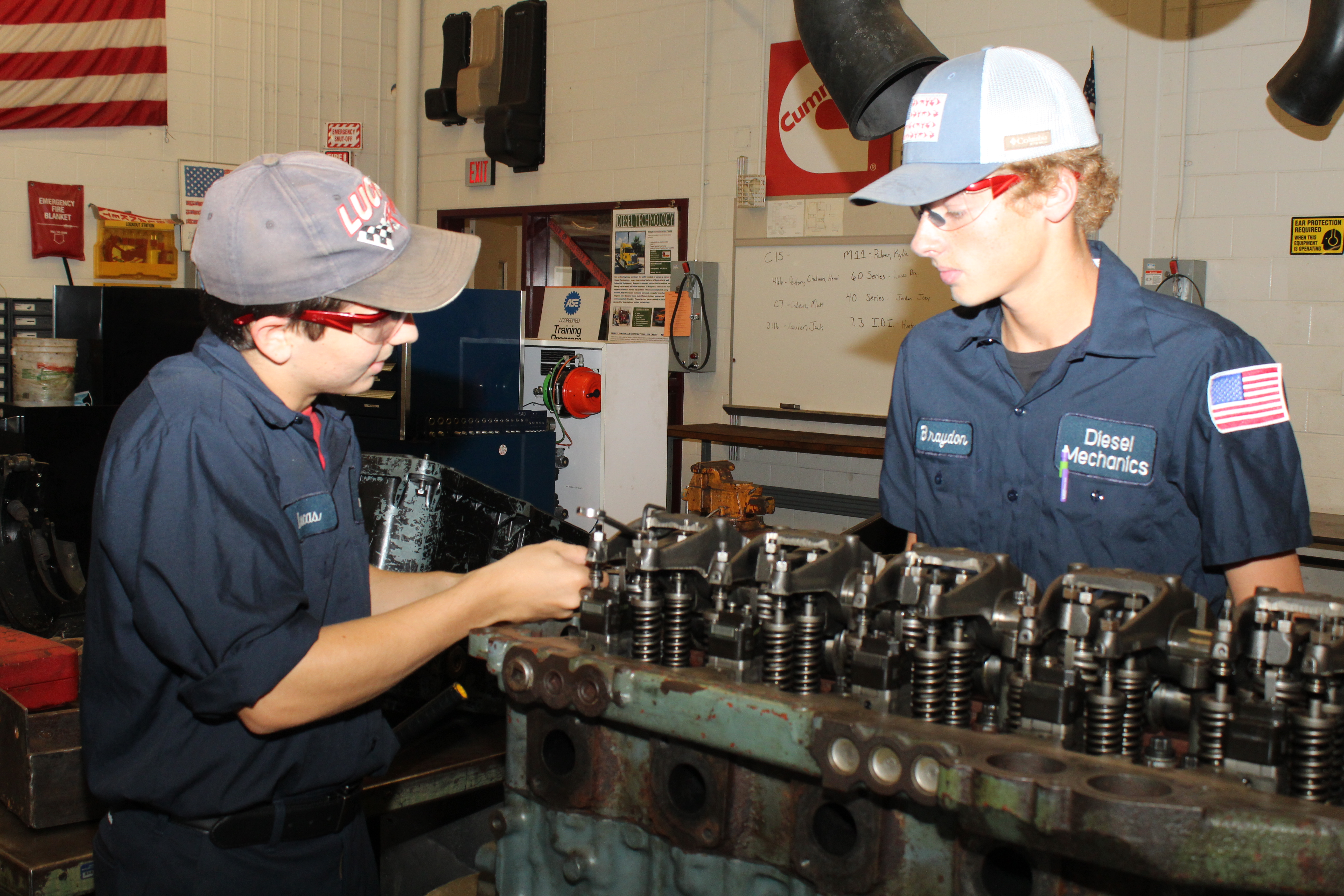 DST Students make adjustments to a demo engine.