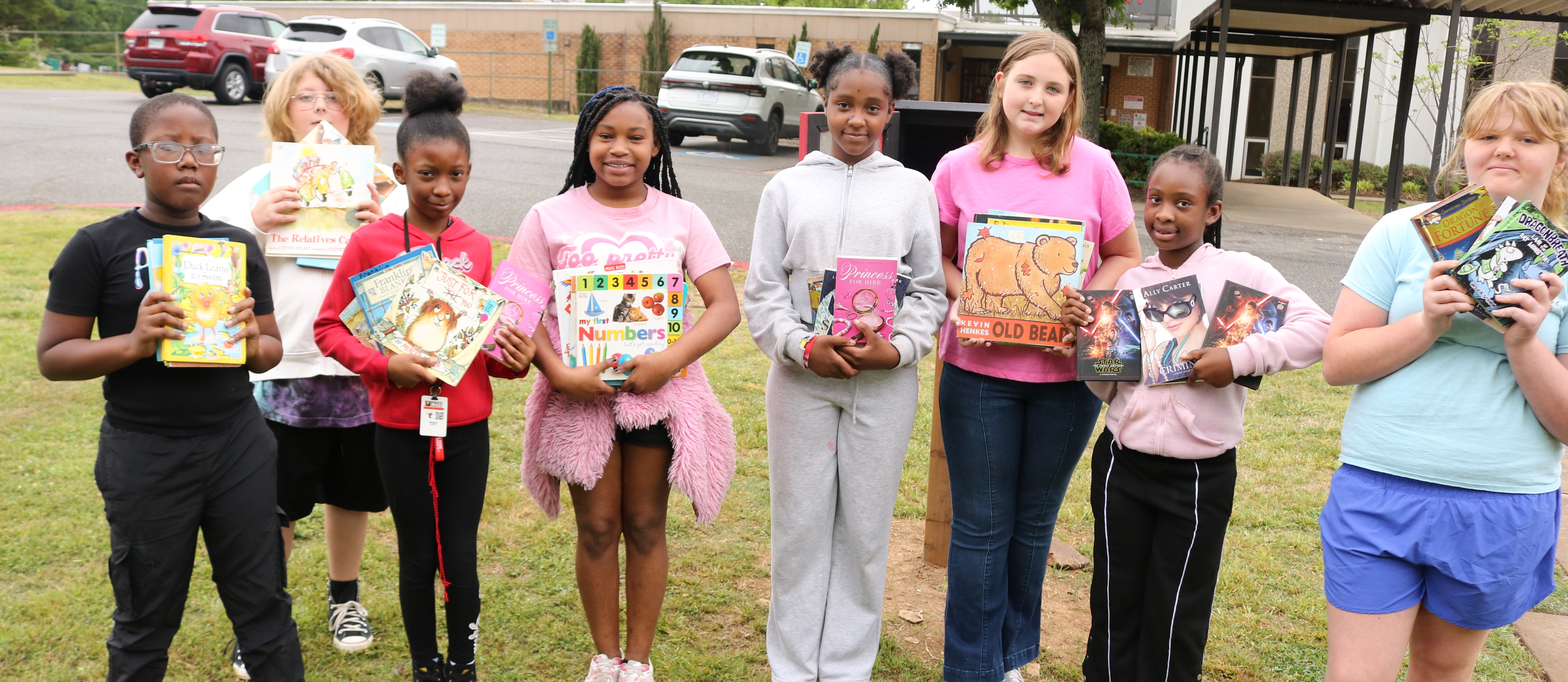 Students lined up with books smiling.