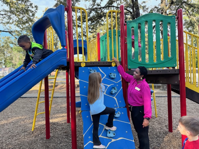 Students on the playground with their principal
