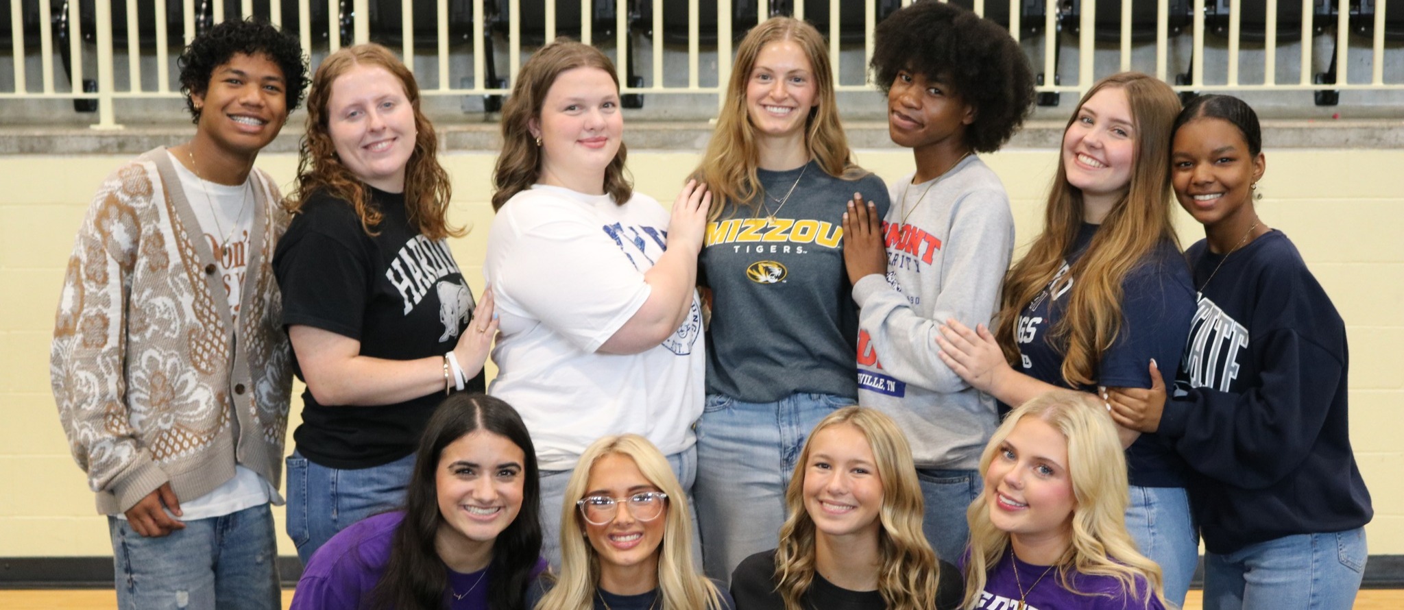 Students pose in various university clothing.