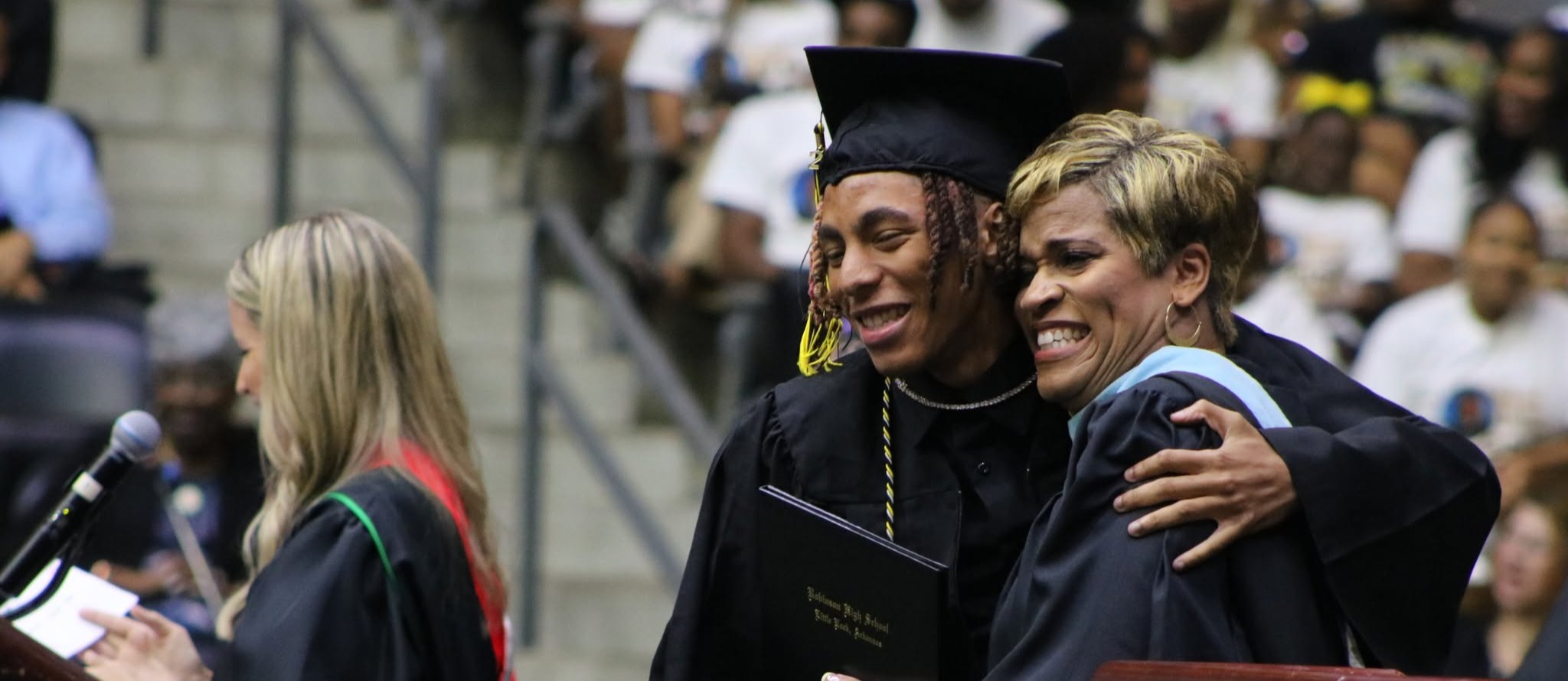 graduating student hugging principal at commencement