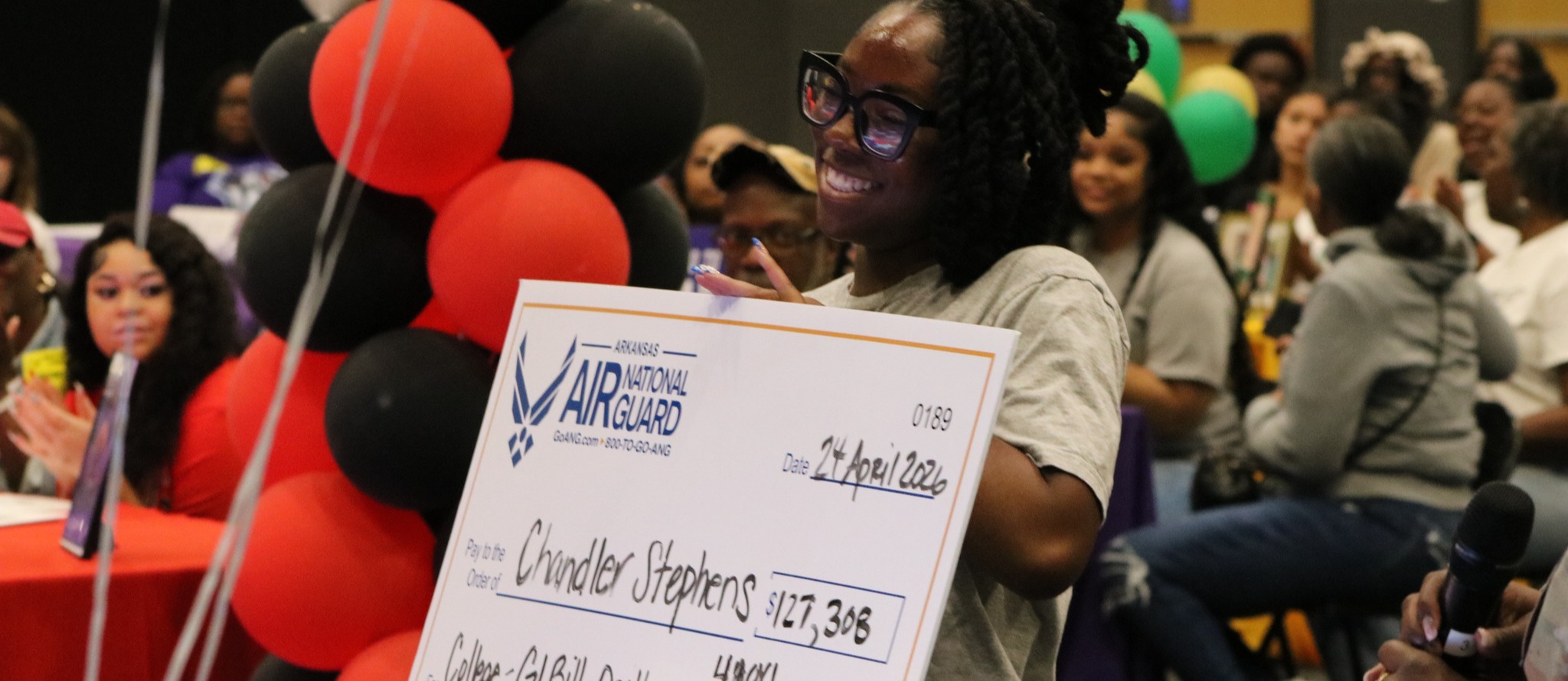 A student holding a Arkansas Air National Guard check.