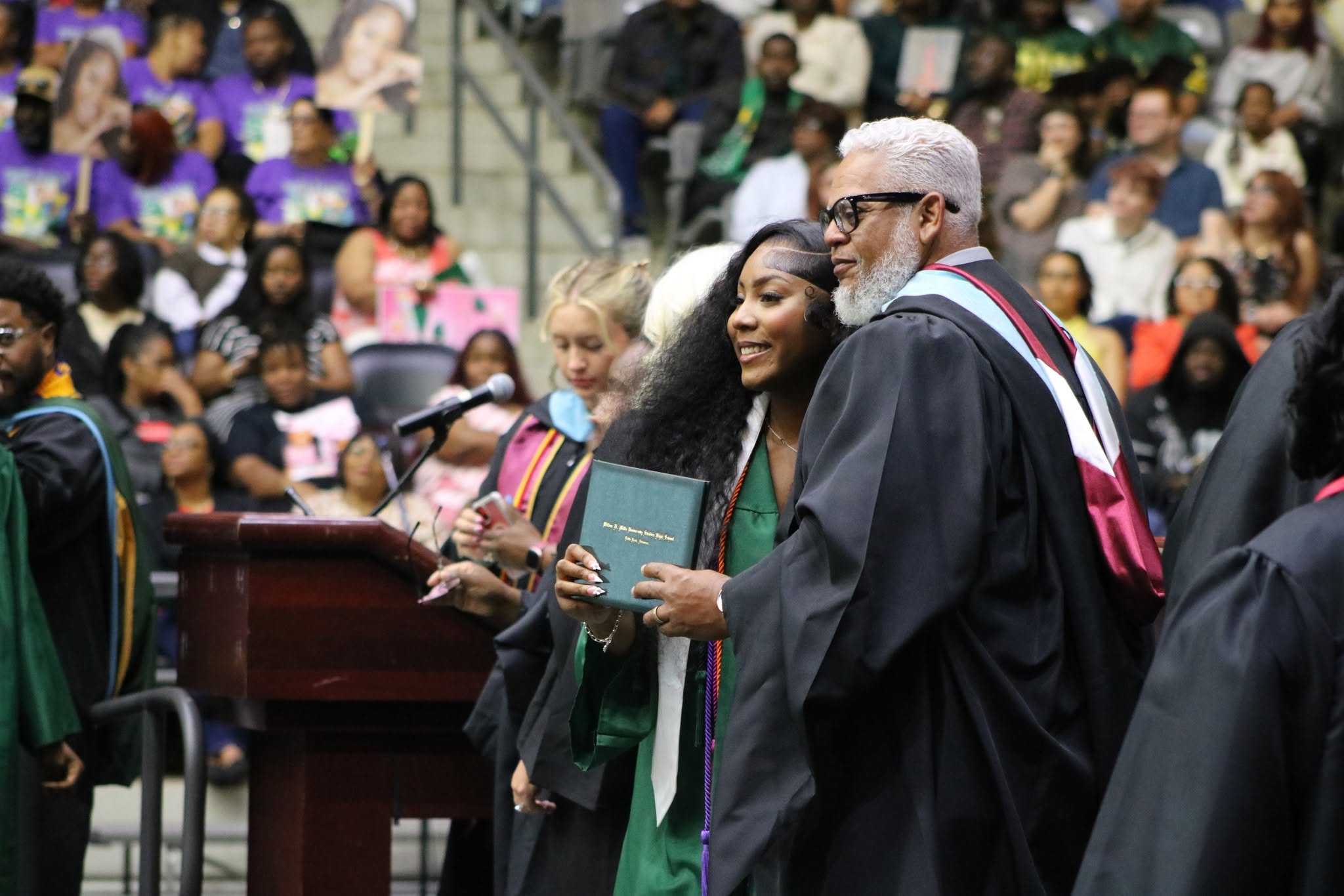 graduating student hugging principal at commencement