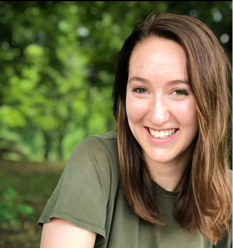 Head shot of Emilee Conroe in front of greenery wearing a green shirt