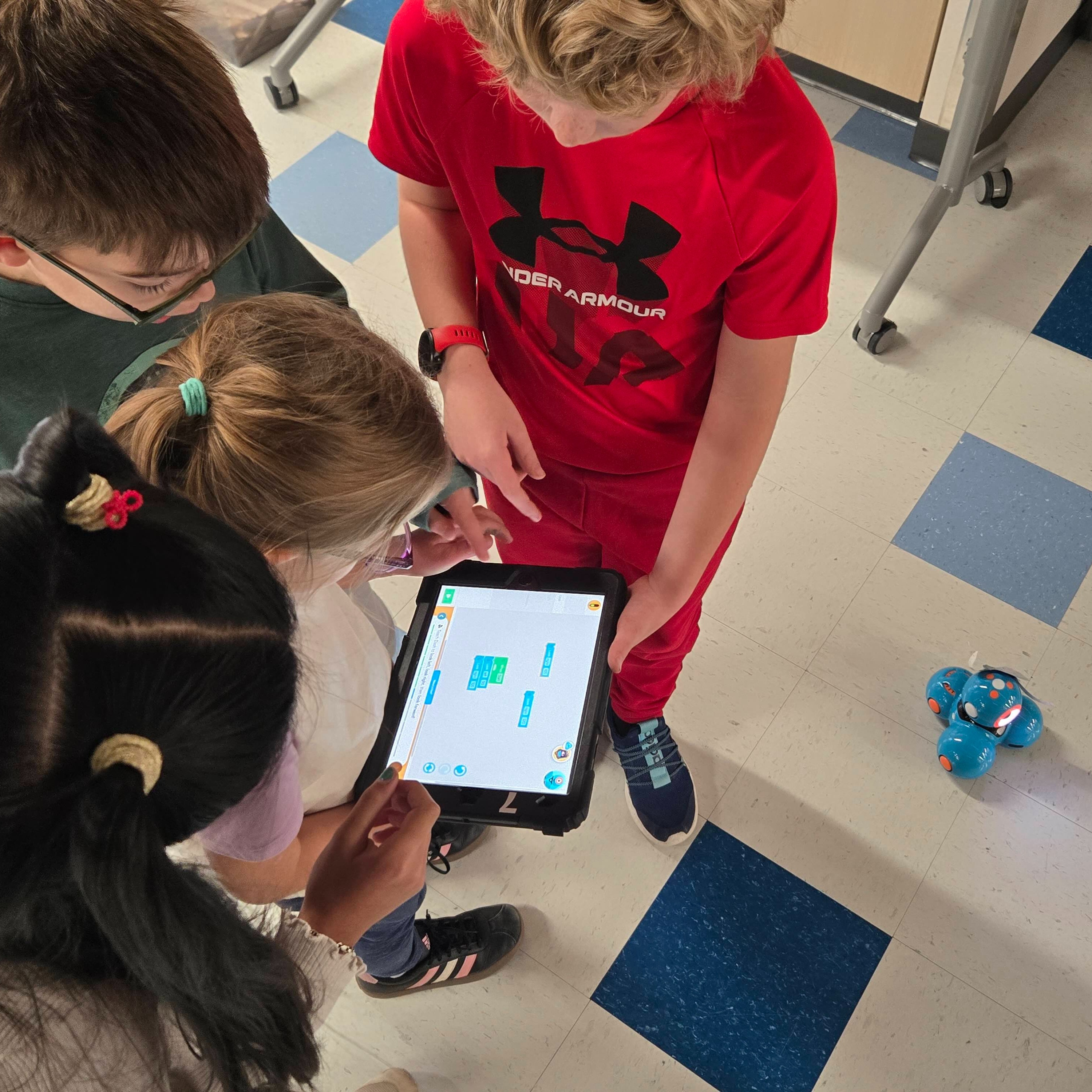 Students using ipad to program a robot