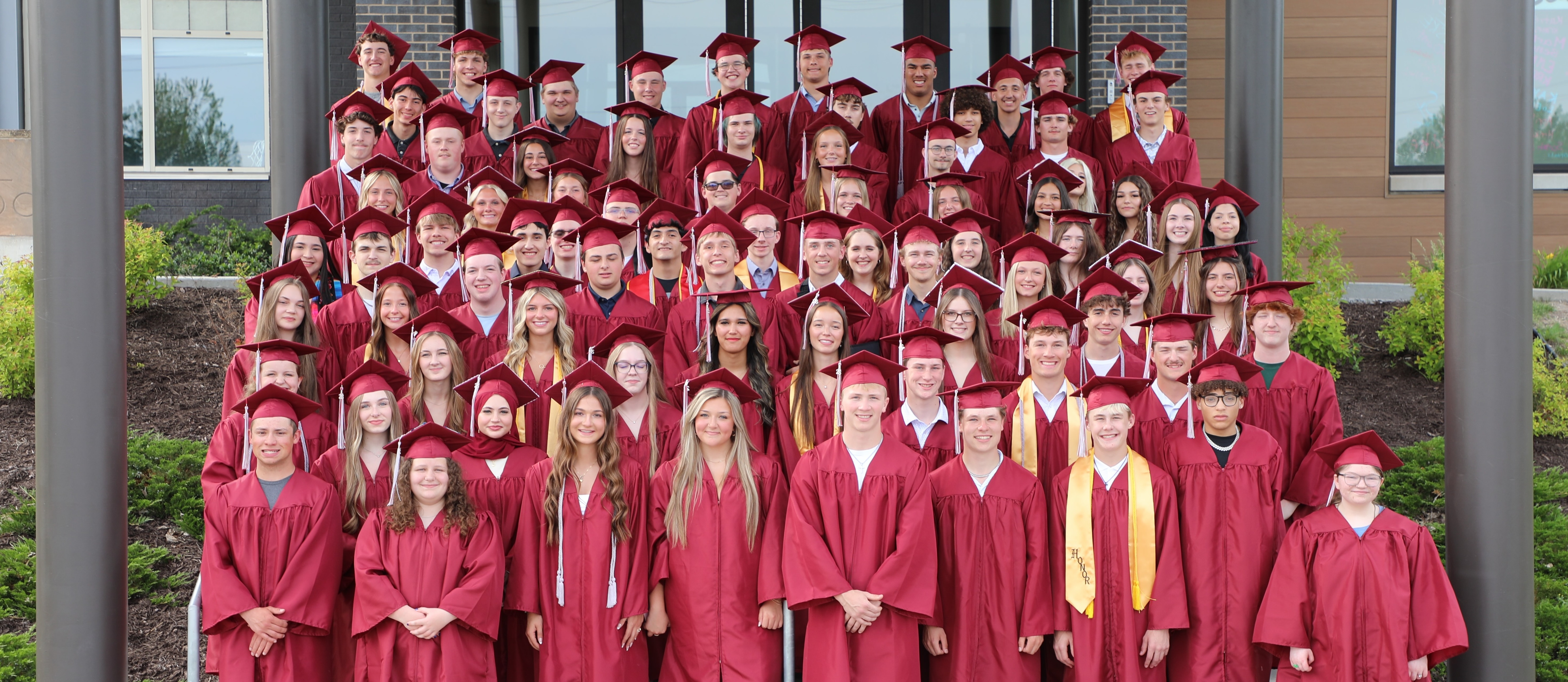 Graduates posing in front of school