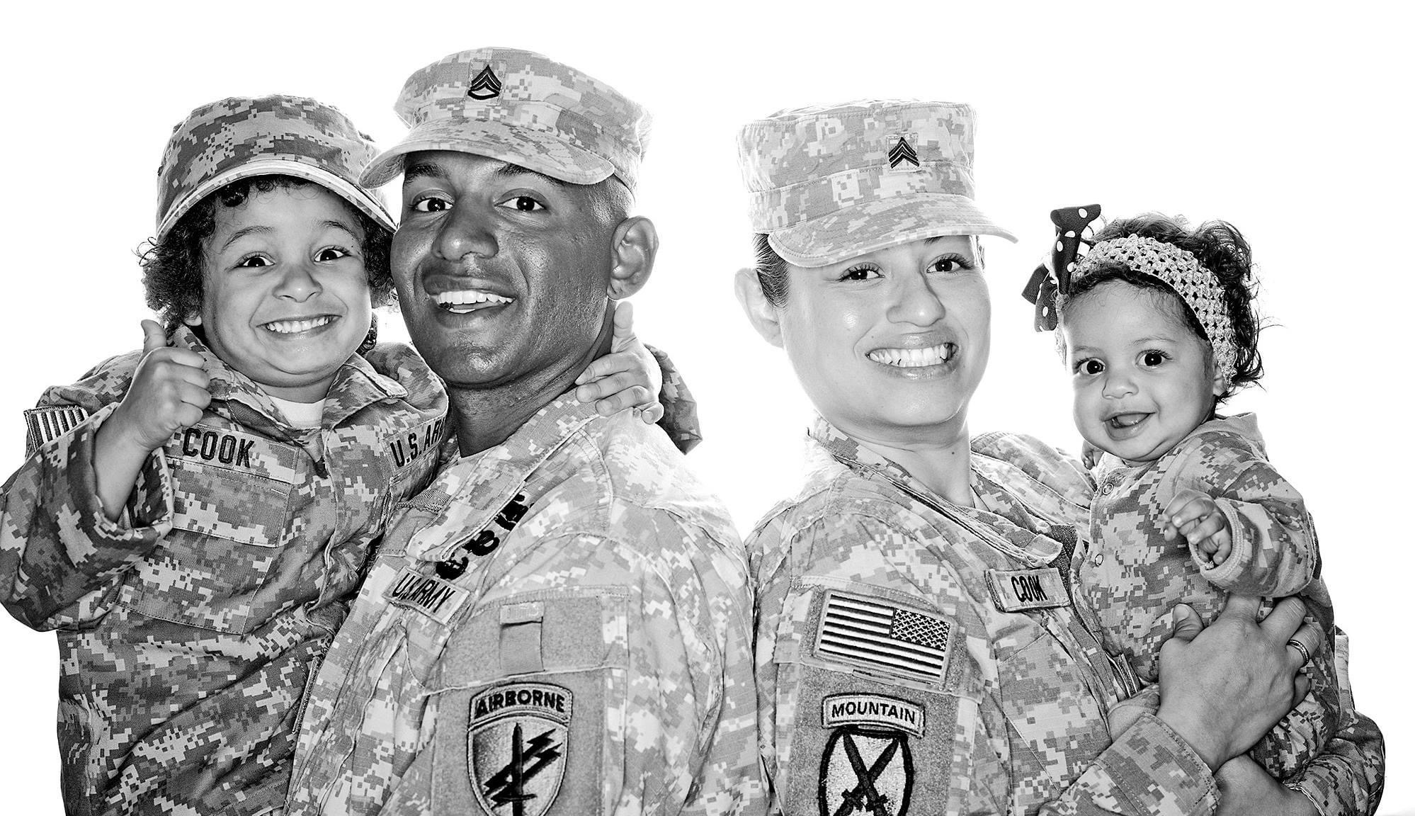 The Cook Family - Husband and wife soldiers  holding their two young children. All wearing military uniforms