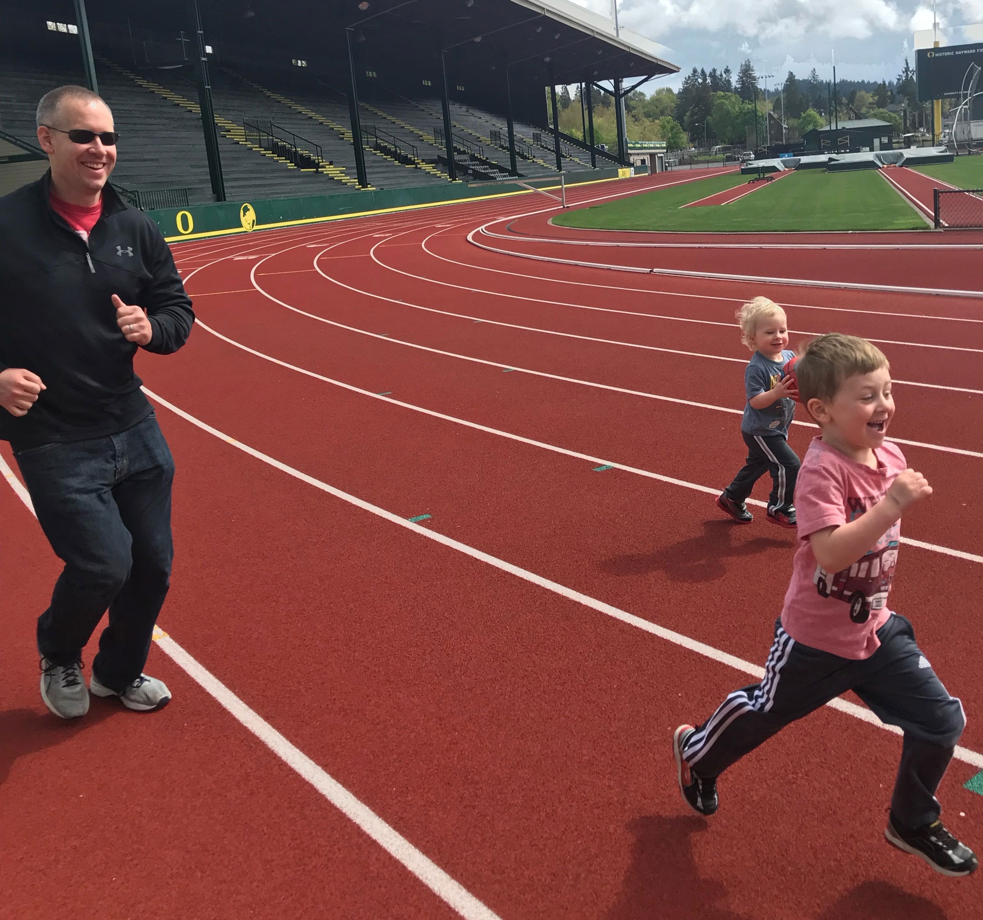 The Sheets family - a father running around a track with his two sons.