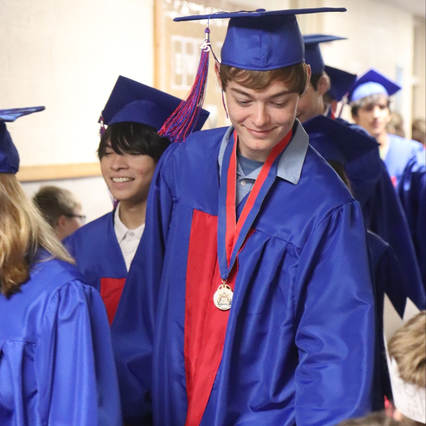 graduate smiles at kindergartener