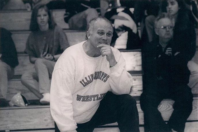 A black and white photo of Pat O'Connor kneeling on the sidelines