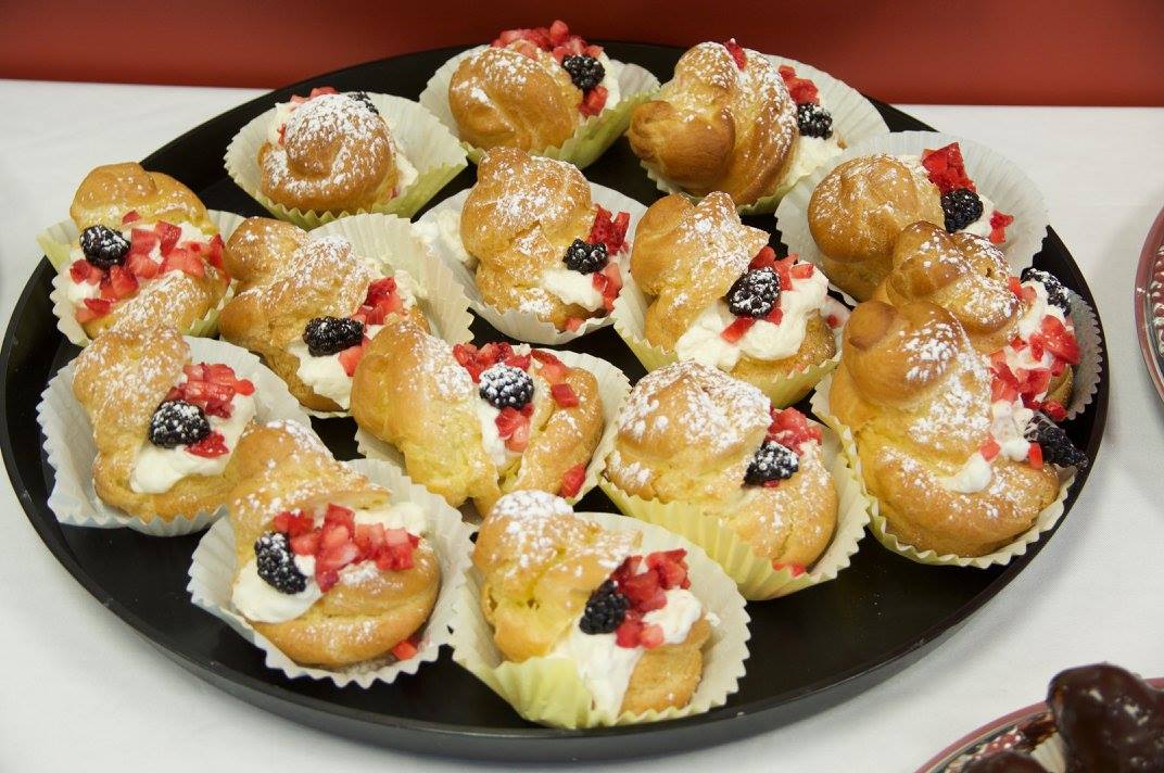 Tray of choux pastries with fresh berries