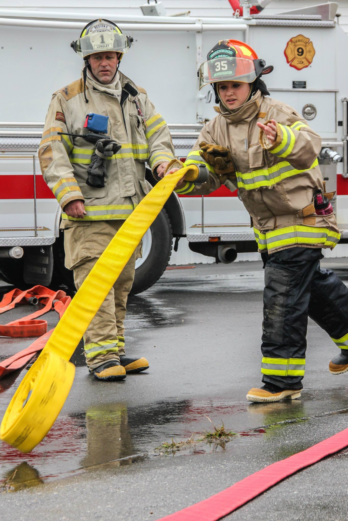 Student practices unrolling fire hose