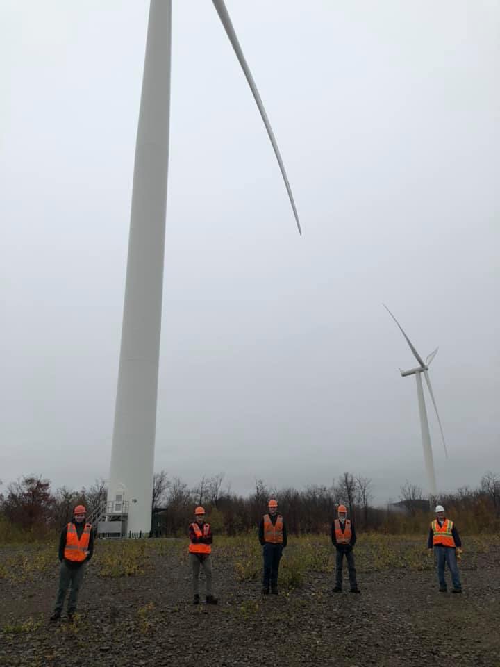 Students stand in front of wind turbines