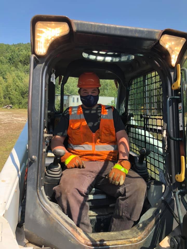 Student smiling from cab of bulldozer